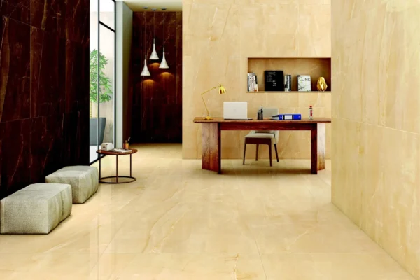 Modern office workspace featuring cream marble flooring, burgundy accent wall, wooden desk with laptop, wall-mounted shelving, and pendant lighting.