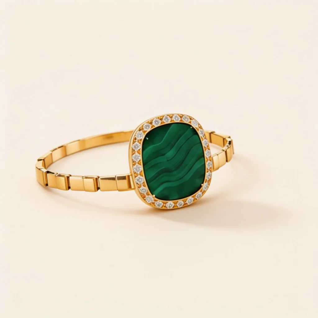 Gold-tone bracelet with emerald green malachite stone surrounded by diamond accents and segmented band design.